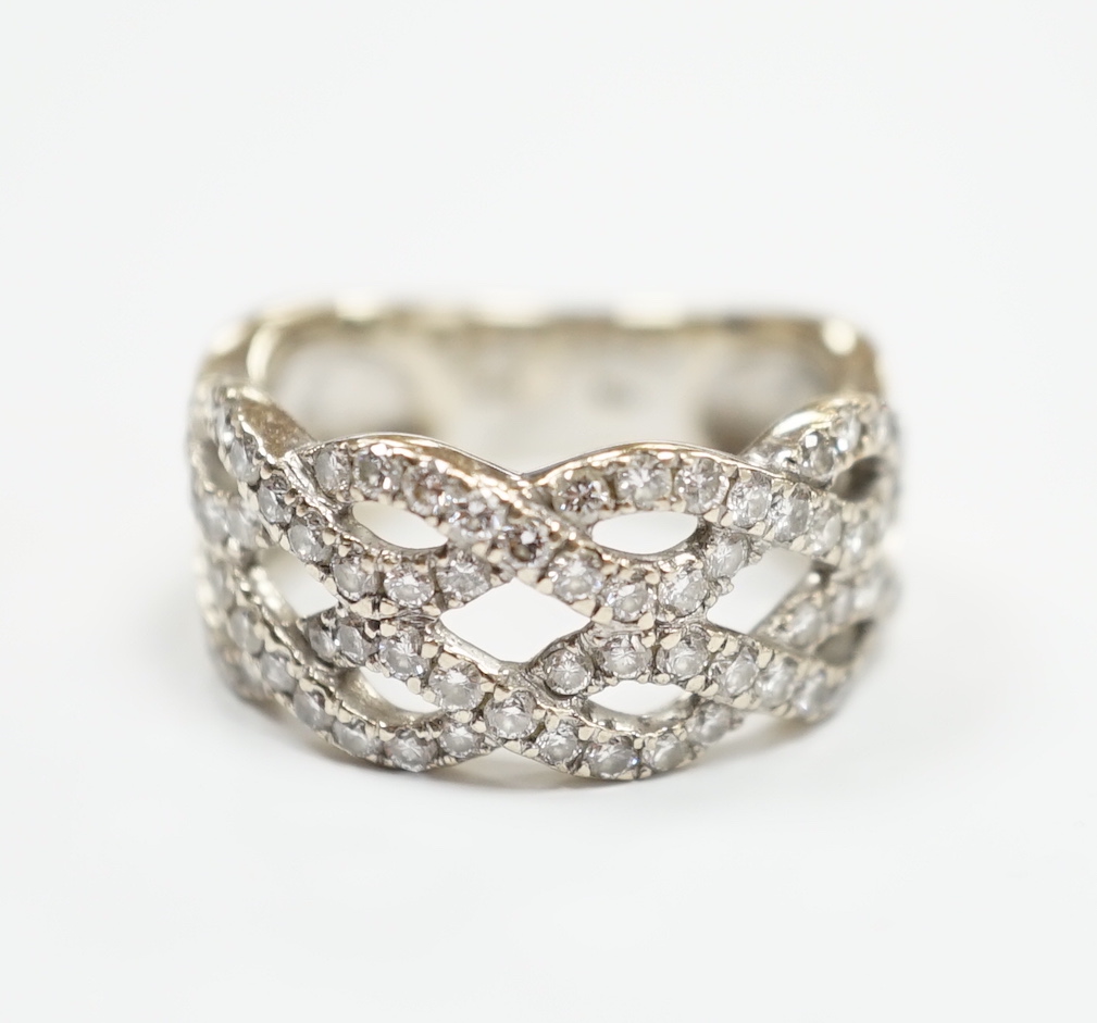 A modern 14k white metal and diamond chip cluster set dress ring, of interwoven design, size M, gross weight 6.4 grams.